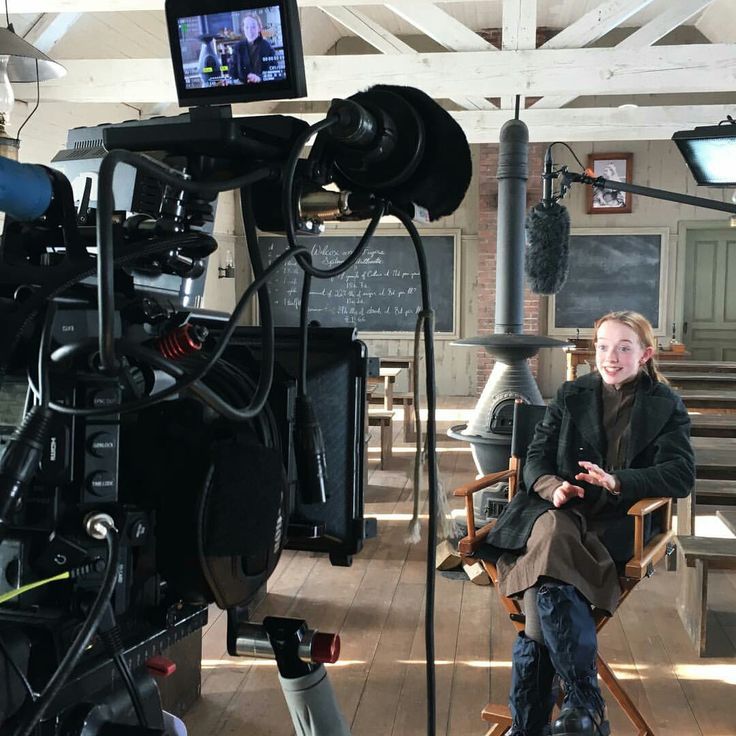 a woman sitting in a chair next to a camera