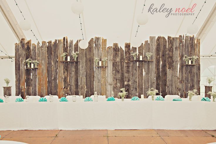 an image of a wooden fence with flowers on the table and chairs in front of it