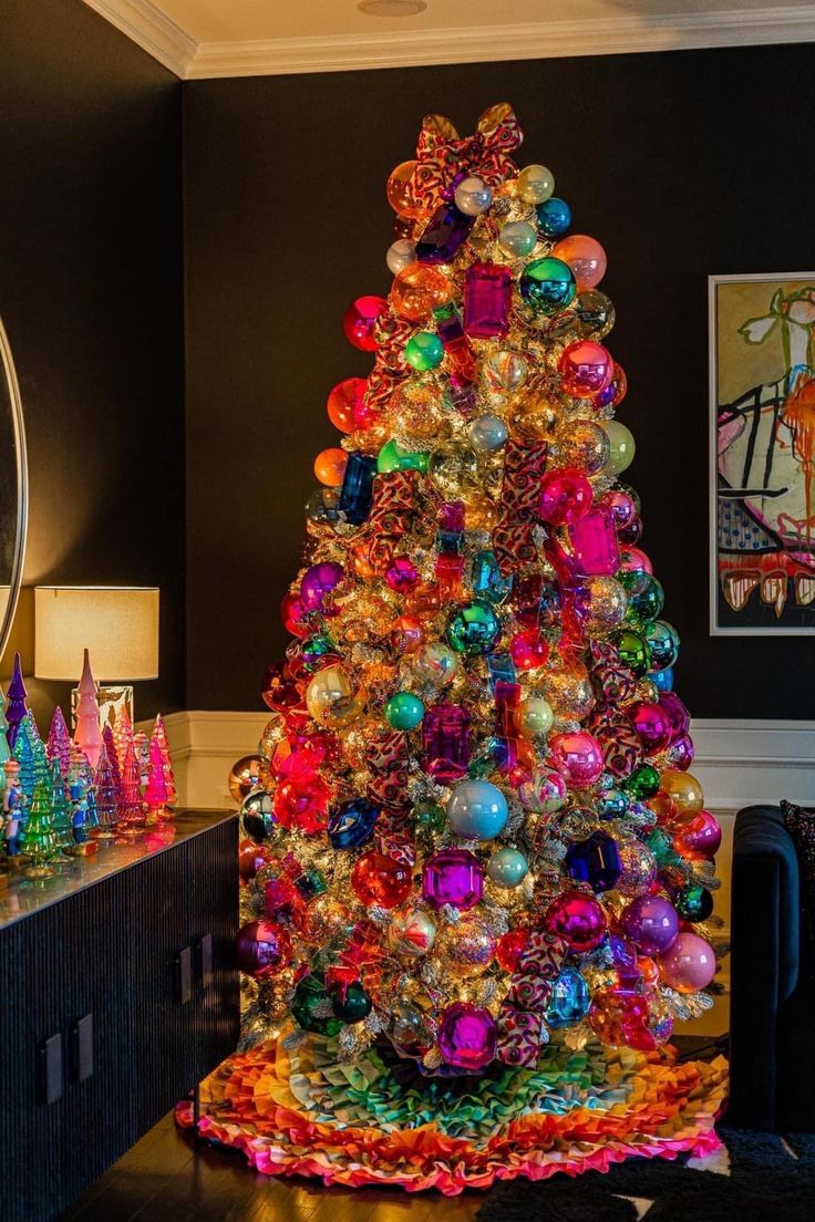 a brightly colored christmas tree in the corner of a living room with black walls and flooring