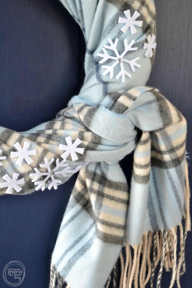 a plaid scarf with snowflakes on it hanging from a blue door frame,