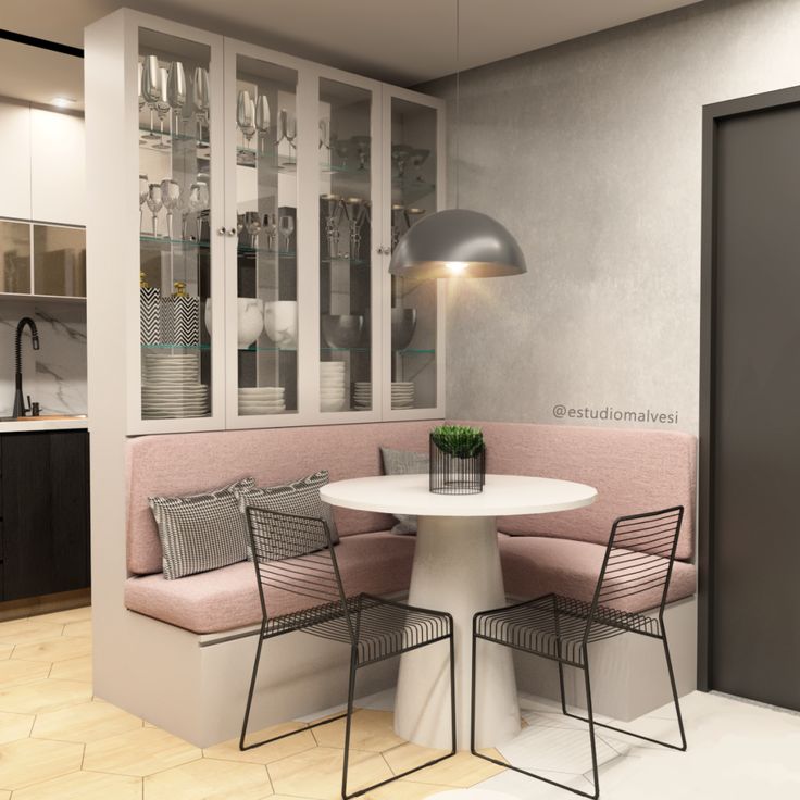 a white table with two chairs and a pink banquet set in front of a gray wall