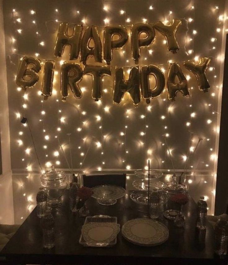 a table with plates and silverware on it in front of a happy birthday sign