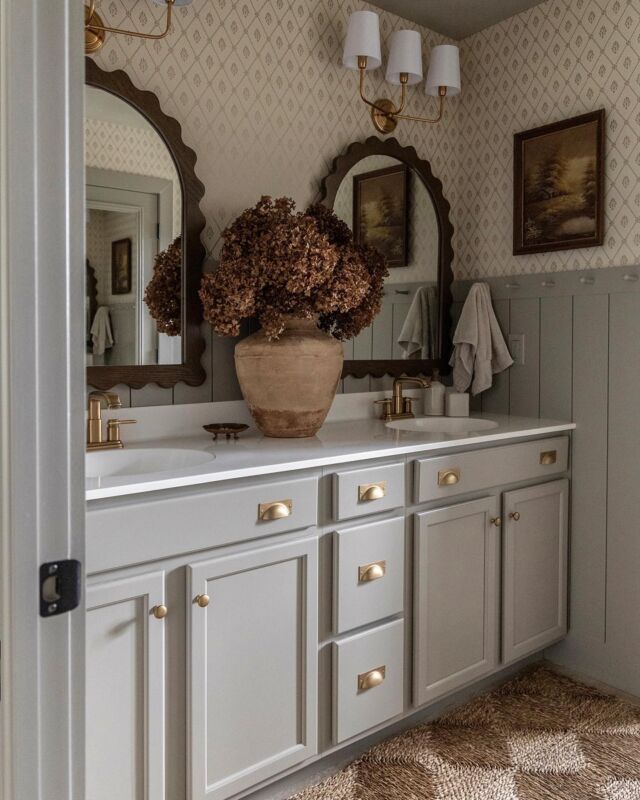 a vase with flowers on top of a bathroom counter