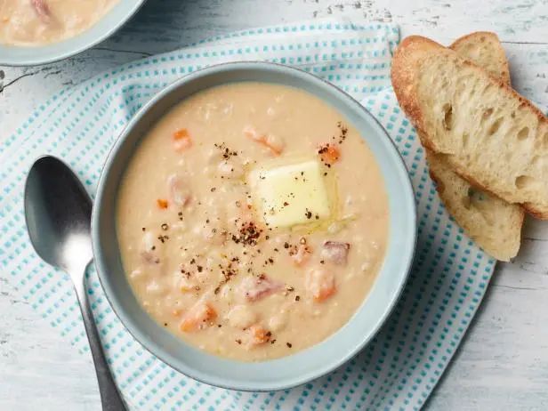 two bowls of soup with bread on the side