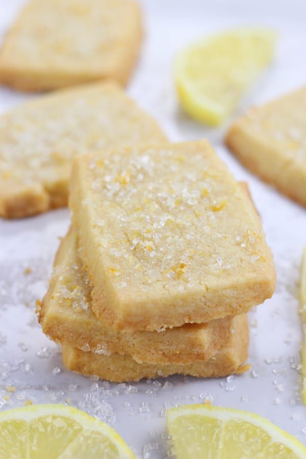 lemon shortbreads with sugar on top and slices of lemon in the background,