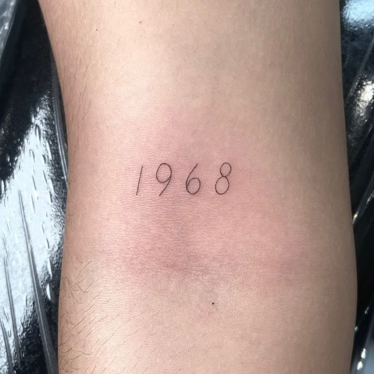 a person with a small tattoo on their leg that says,'1960'in black ink