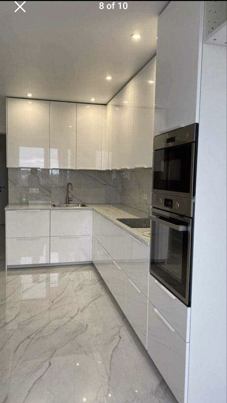 a kitchen with marble floors and white cabinets