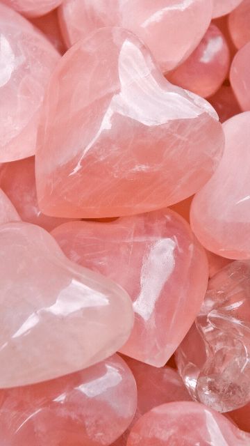 some pink rocks are laying on top of each other and one has a heart shaped rock in the middle