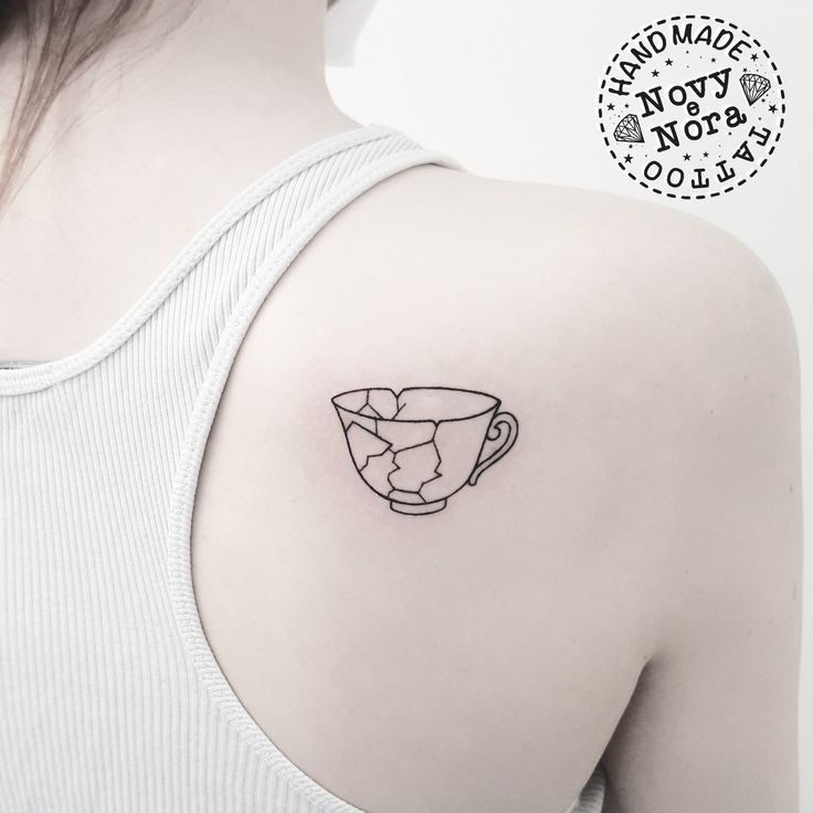 a woman with a cup tattoo on her shoulder