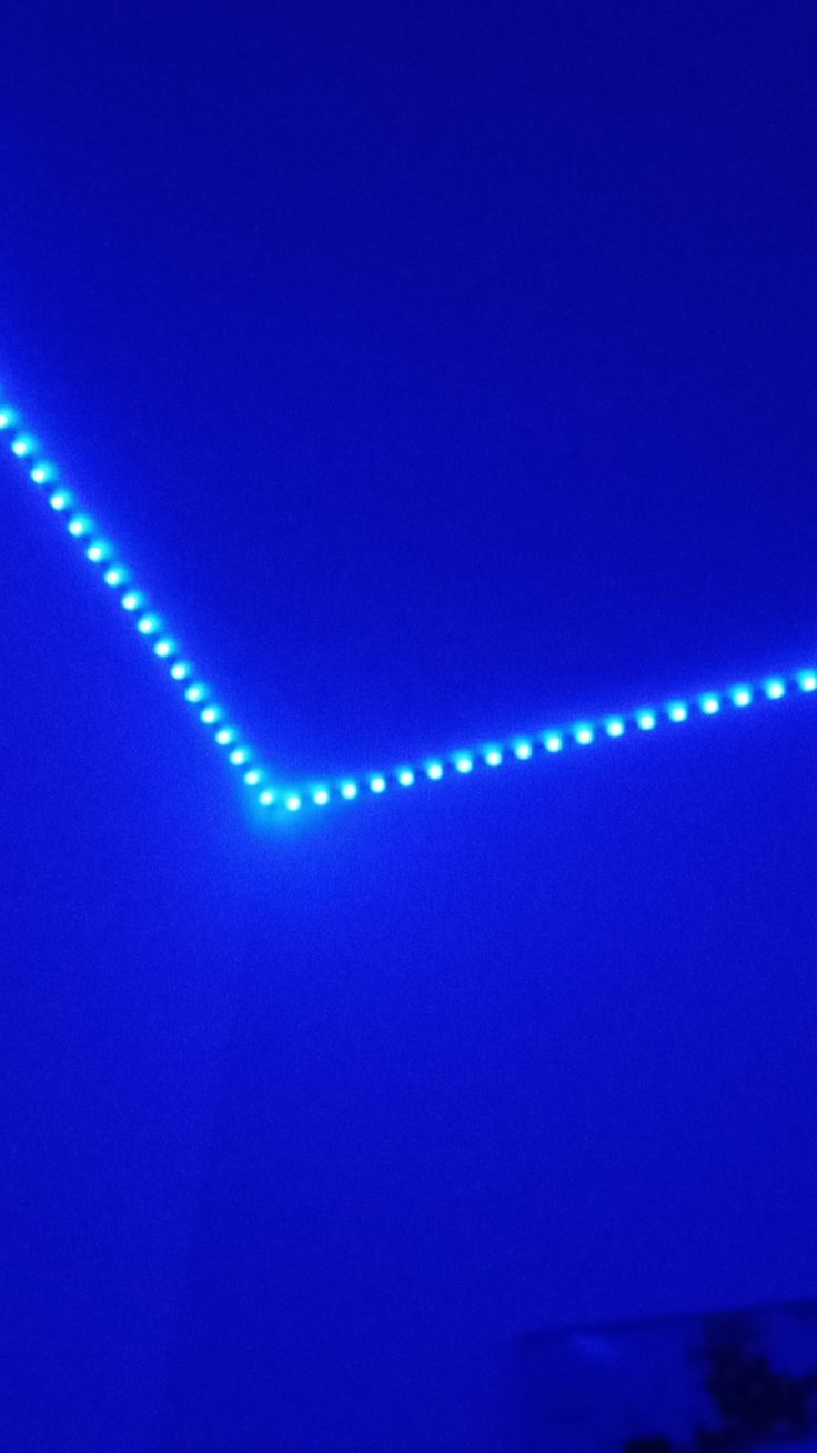 an airplane is flying through the air with blue lights on it's sides and bottom