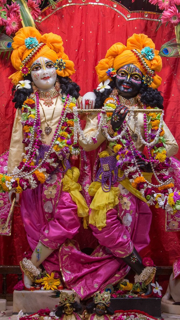 two men dressed in colorful costumes standing next to each other