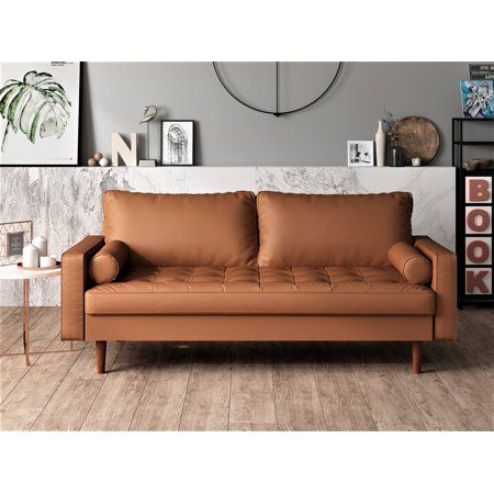 a brown leather couch sitting on top of a hard wood floor