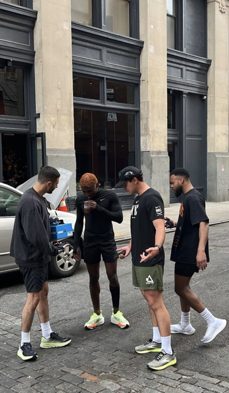 four men walking down the street talking to each other