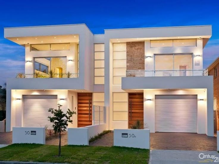 two story house with white walls and lights on the windows at night in suburbs, australia