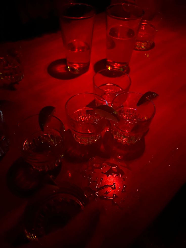 a table topped with lots of glasses filled with liquid