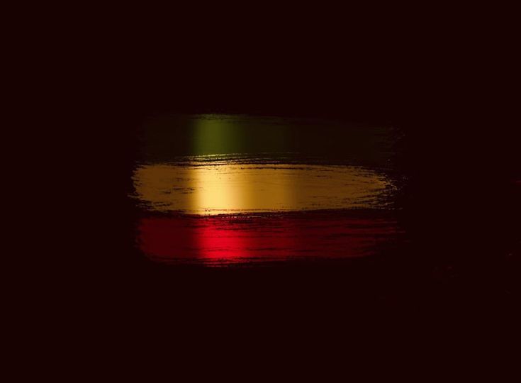 a red, yellow and green background with some light reflecting on the ground in it