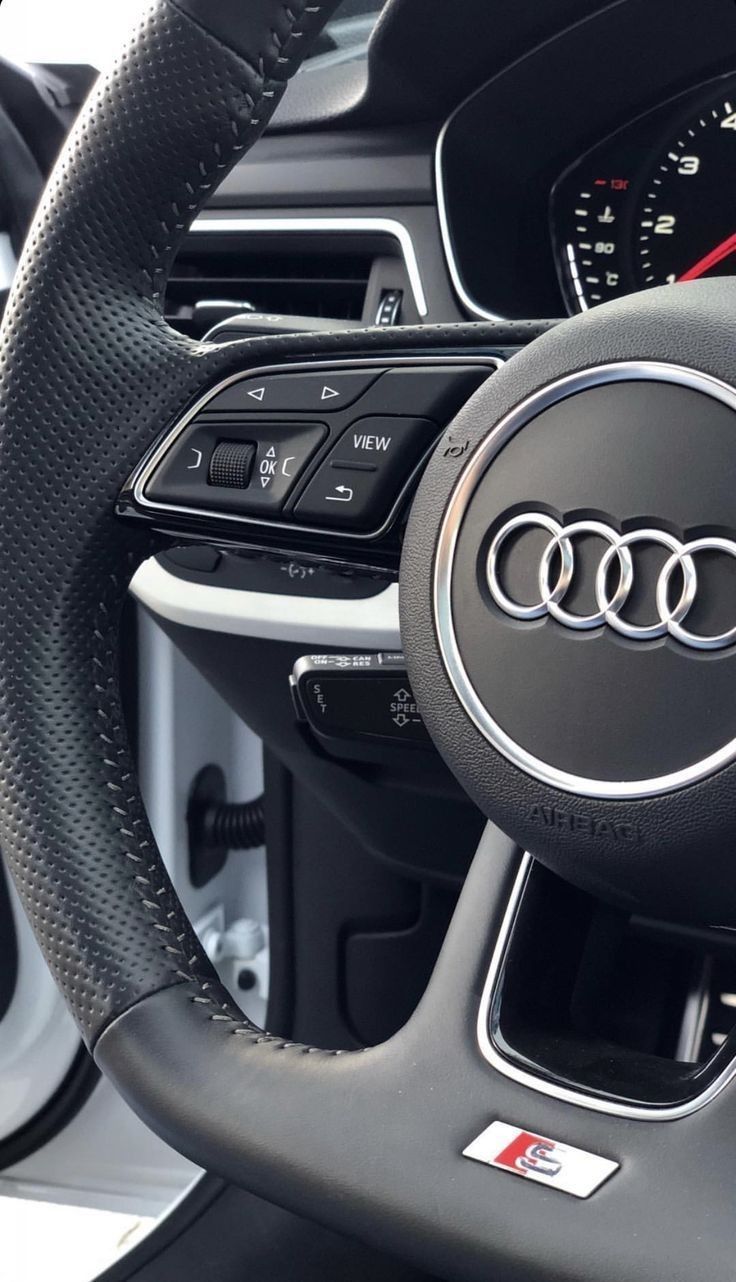 the steering wheel and dashboard of an audi car