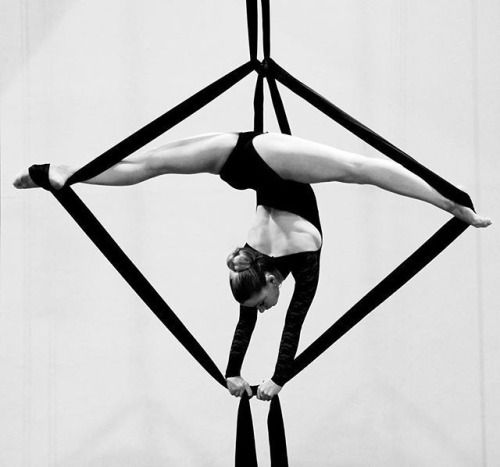 a woman is doing aerial acrobatic tricks