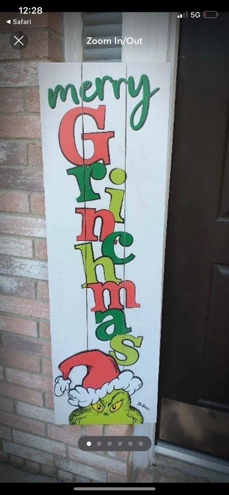 a sign that says merry christmas hanging from the side of a brick wall in front of a door