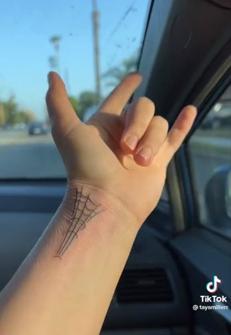 a person's arm with a small tattoo on the middle of their left hand