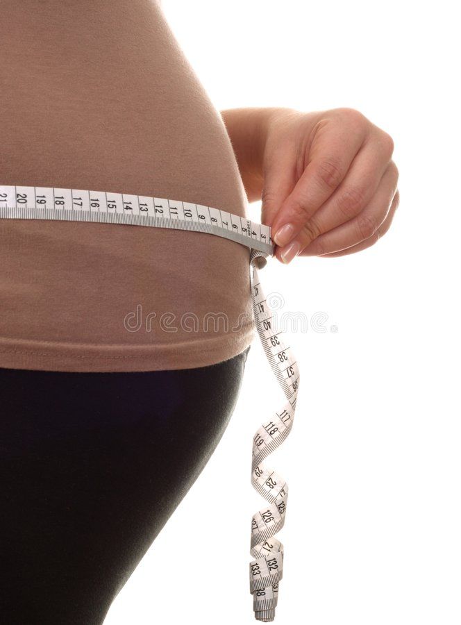 a pregnant woman measuring her waist with a tape royalty images and clippings on the belly