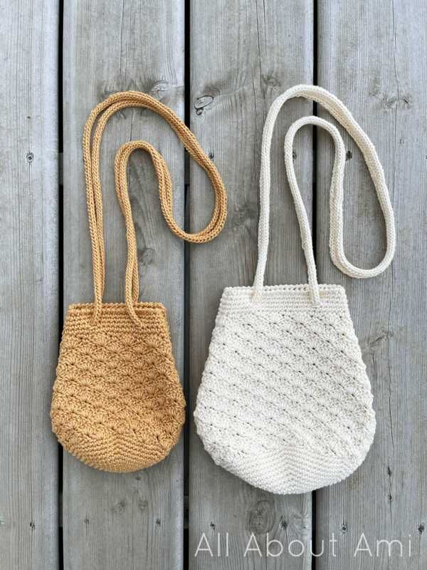 two crocheted purses sitting on top of a wooden table next to each other