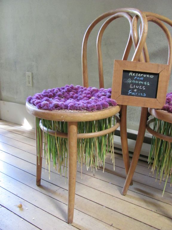 two wooden chairs with purple flowers on them and a chalkboard attached to the back