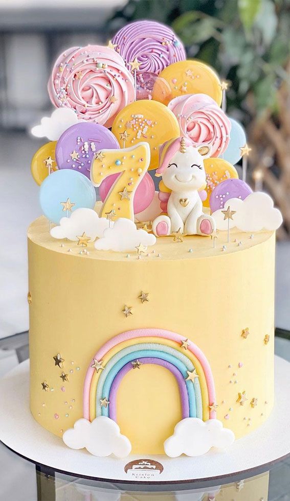 there is a yellow cake with rainbow decorations on it