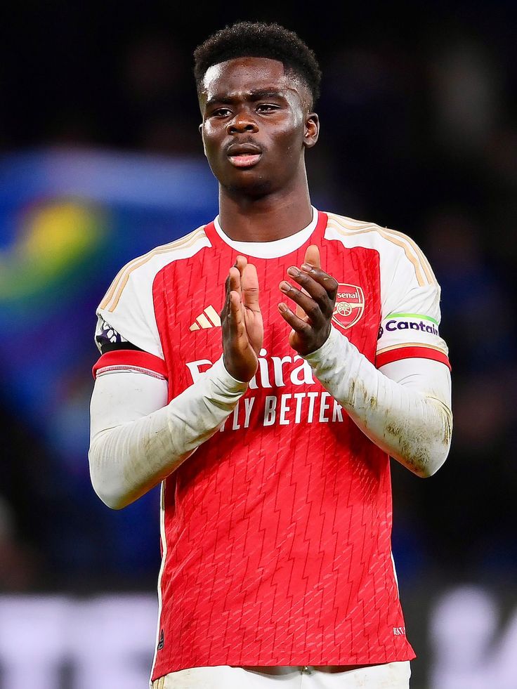 a soccer player is applauding the crowd with his hands together while wearing a red and white uniform