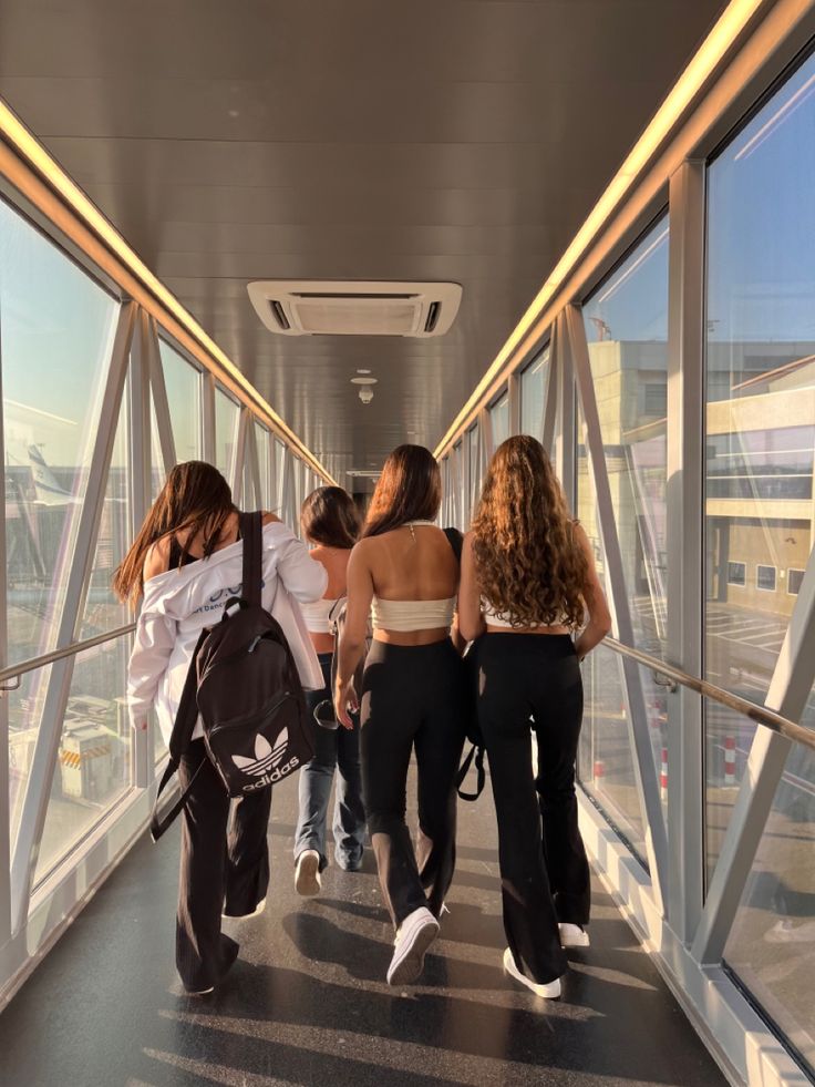 several people are walking down a glass walkway