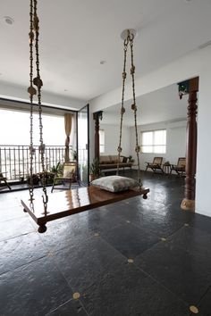 a living room filled with furniture next to a large open window and swing set on the floor