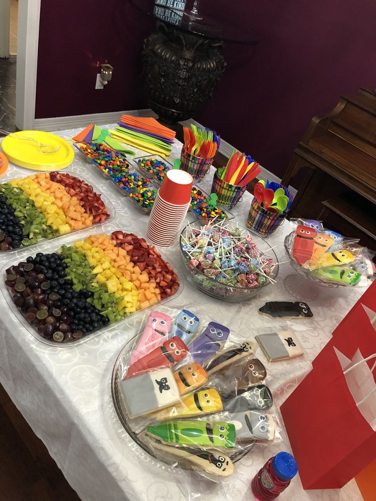 a table topped with lots of candy and candies on top of a white table cloth