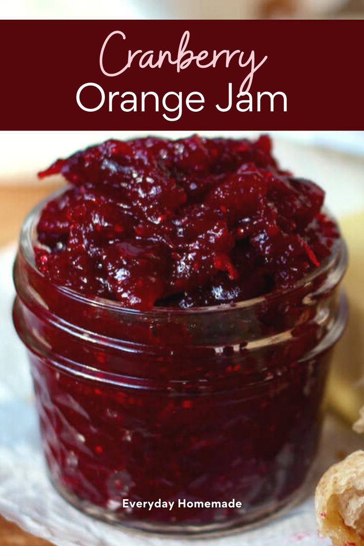 cranberry orange jam in a small glass jar with a biscuit on the side