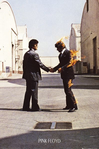 two men in suits shaking hands with each other on the street, one holding fire