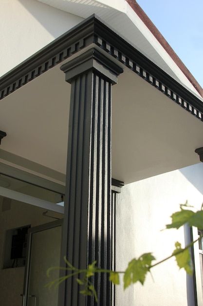 the corner of a building with a black and white column on it's side