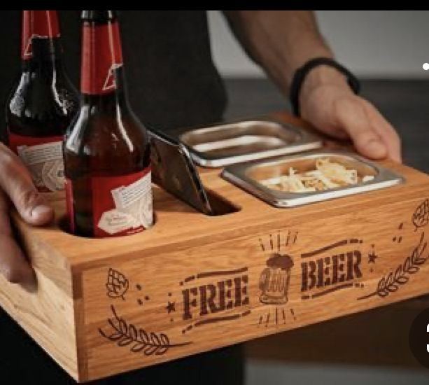 a man holding a wooden tray with two bottles of beer and a bowl of food