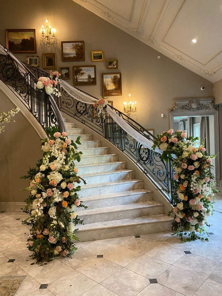 two floral arrangements on the steps of a grand staircase