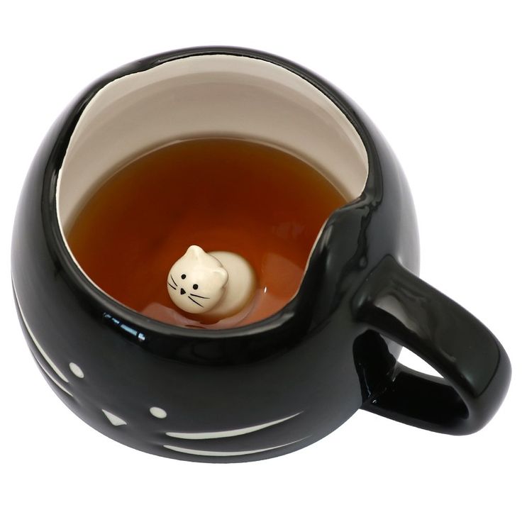 a black tea cup with a white cat in it