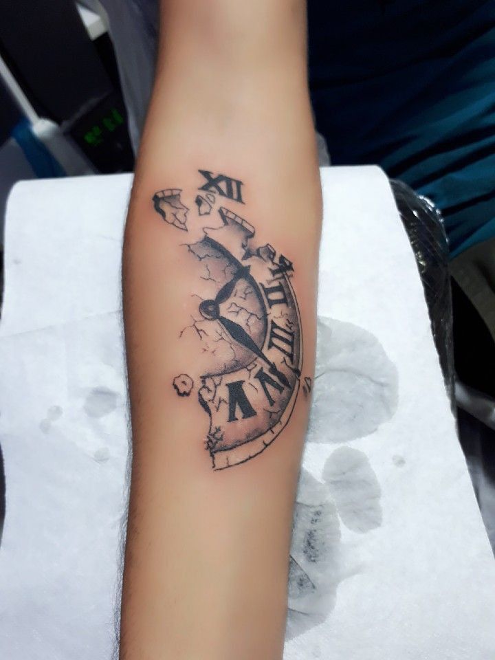 a person with a clock tattoo on their arm