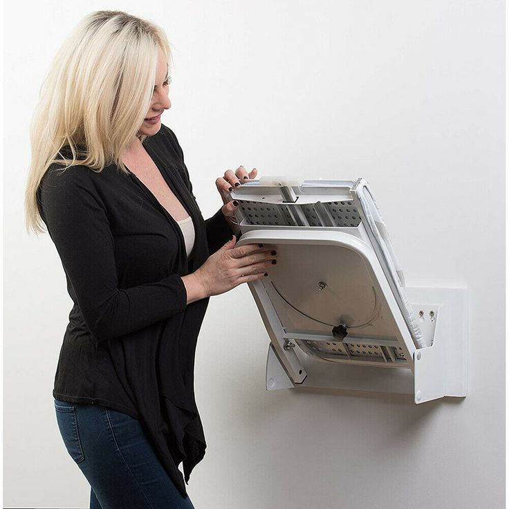 a woman is looking at an appliance on the wall