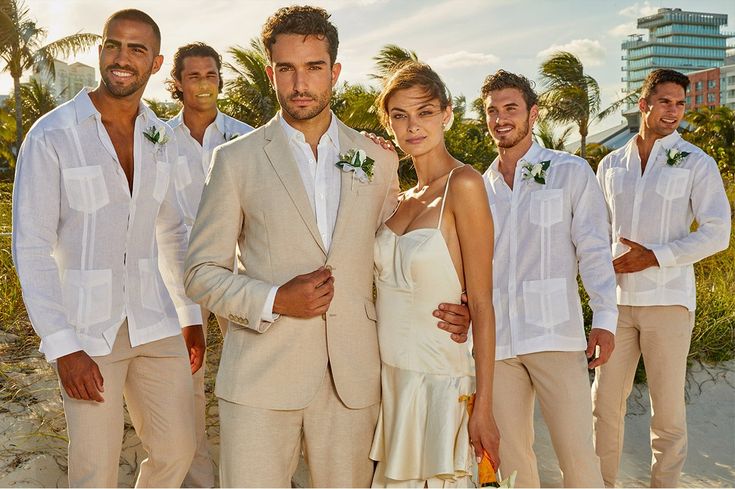 a group of men and women standing next to each other in front of palm trees