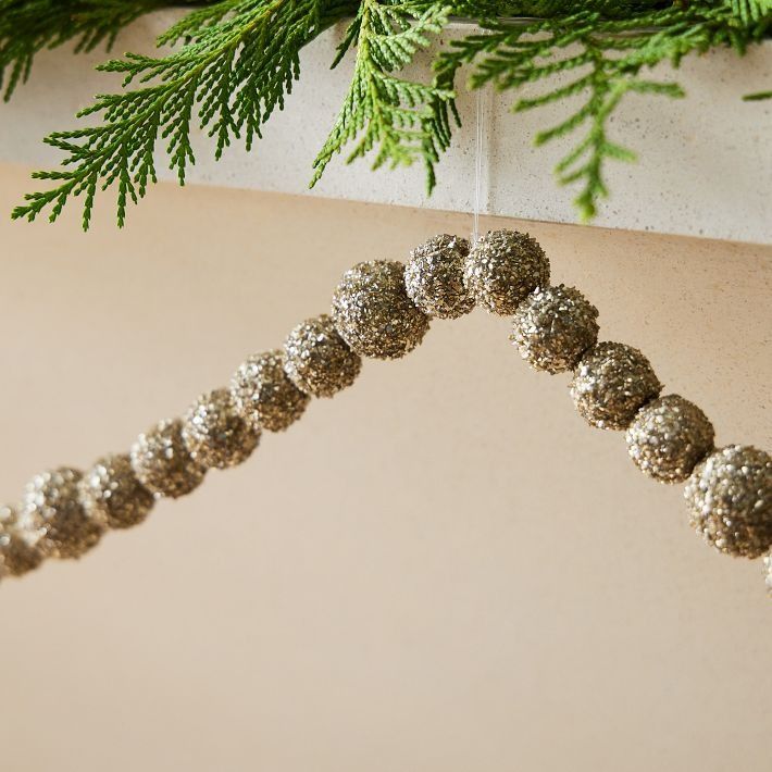 a christmas tree branch with silver balls hanging from it's side and green needles