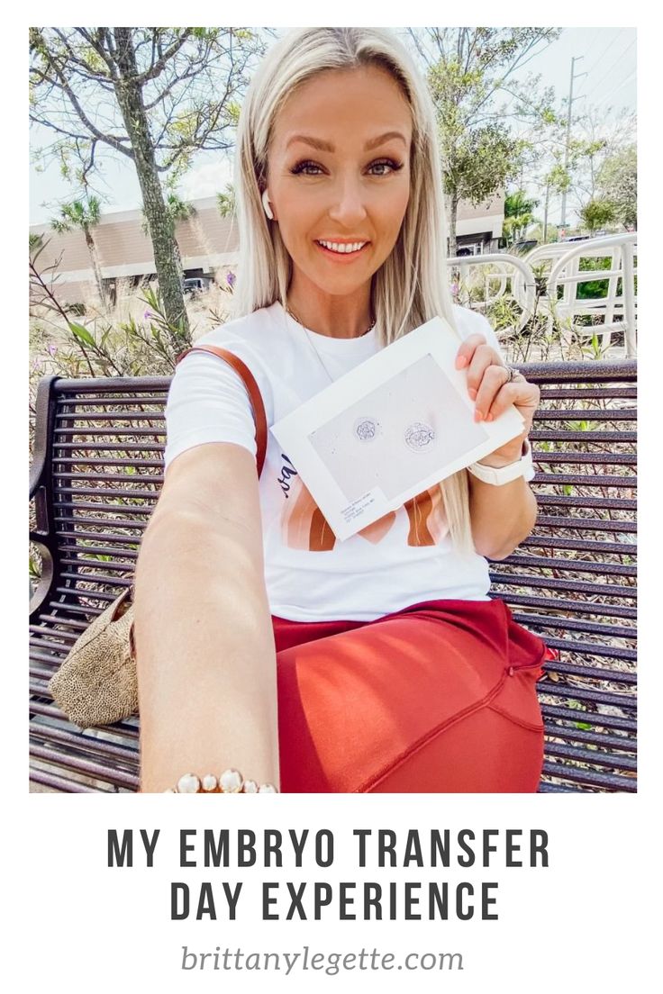 a woman sitting on top of a wooden bench holding up a white box with the words my embro transferer day experience