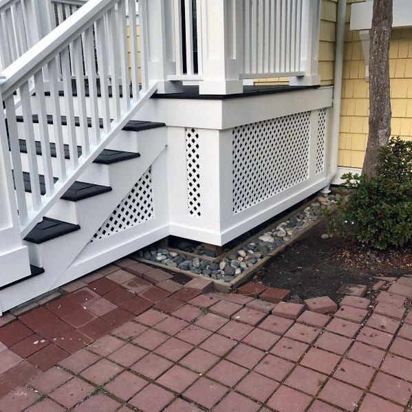 a white stair case next to a brick walkway