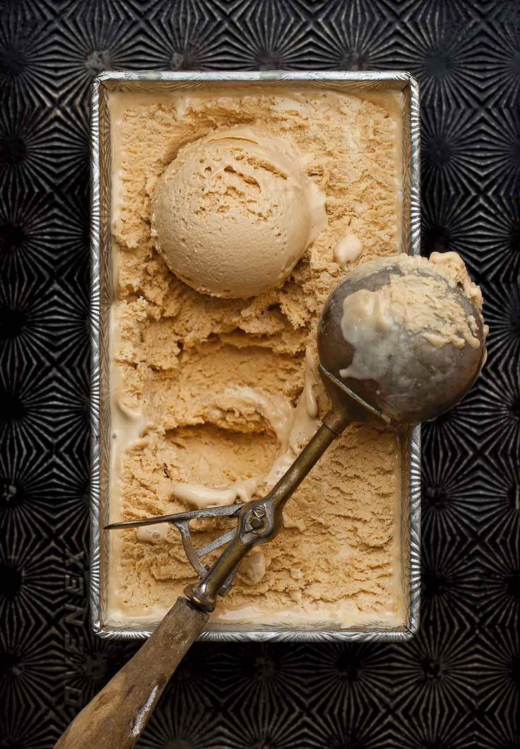 two scoops of ice cream on top of a metal pan with a spoon in it