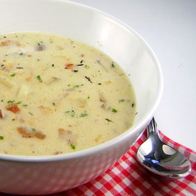 a white bowl filled with soup on top of a red and white checkered table cloth