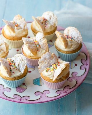 small cupcakes with frosting and sprinkles on a pink plate