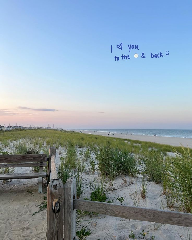 a wooden bench sitting on top of a sandy beach