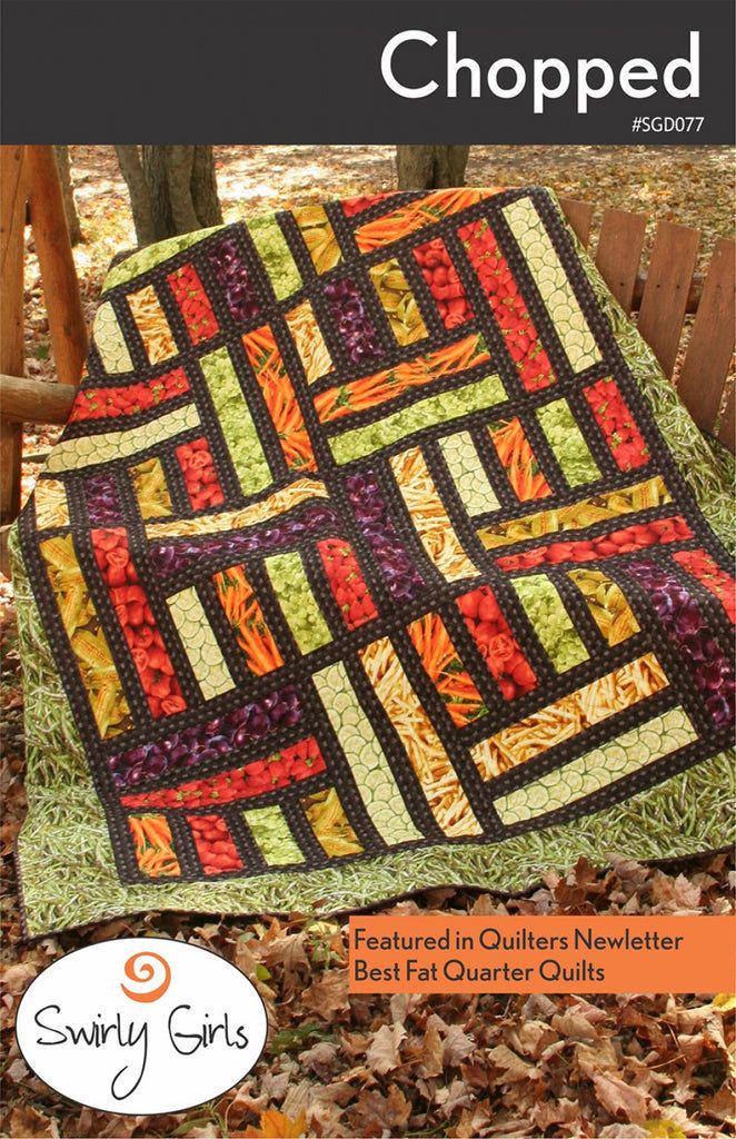 a quilted blanket sitting on top of a wooden chair next to leaves and grass