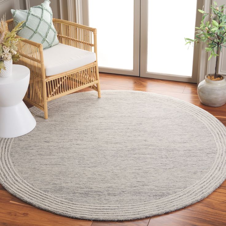 a living room area with a chair, rug and potted plant on the floor